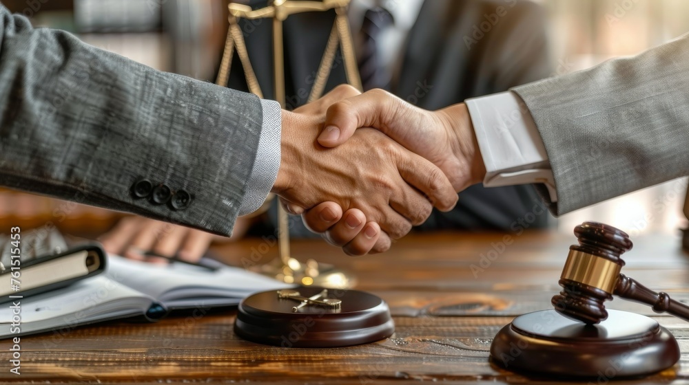 Two People Shaking Hands in Front of a Scale of Justice Two People Shaking Hands in Front of a Scale of Justice