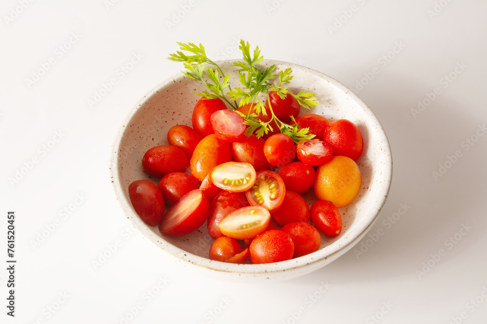 Cherry tomatoes inside a white ceramic bowl in white clean background aerial view Cherry tomatoes inside a white ceramic bowl in white clean background aerial view