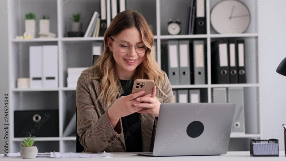Cheerful and smiling Caucasian woman texting using phone during office break. Relaxing online, telecommunication, internet browsing, chatting in social media. Cheerful and smiling Caucasian woman texting using phone during office break. Relaxing online, telecommunication, internet browsing, chatting in social media.