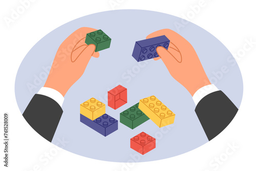 Hands businessman with toy bricks as metaphor for reorganization and restructuring company for reformation of business processes. Businessman is engaged in rebuilding own corporation or team building