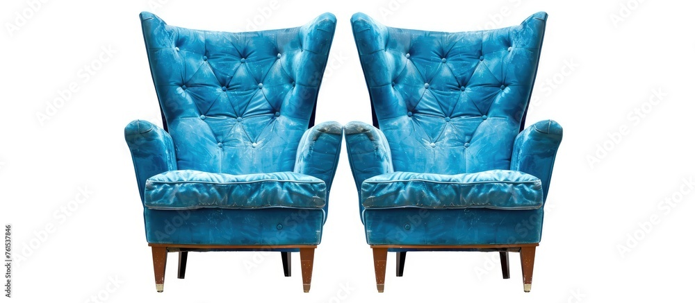 Two blue chairs are placed next to each other on a white background ...
