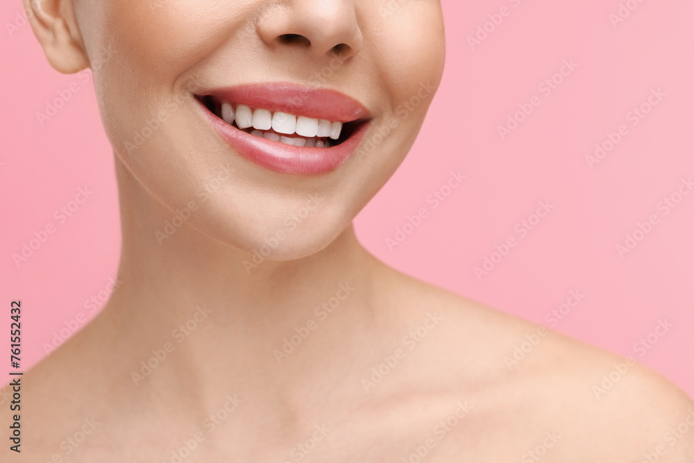 Obraz premium Woman with beautiful lips smiling on pink background, closeup