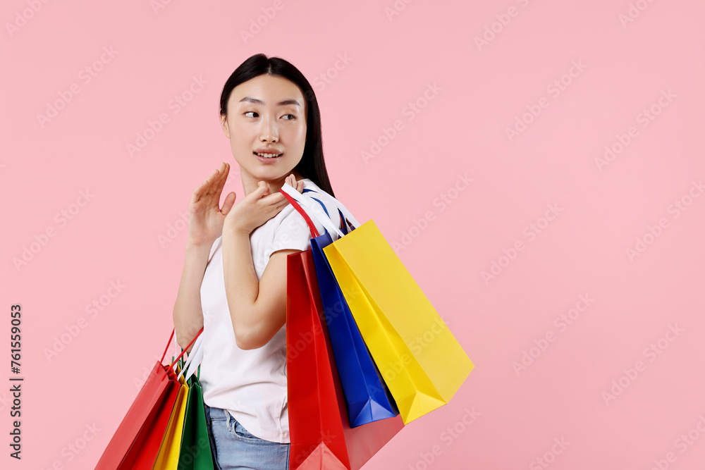 Smiling woman with shopping bags on pink background. Space for text