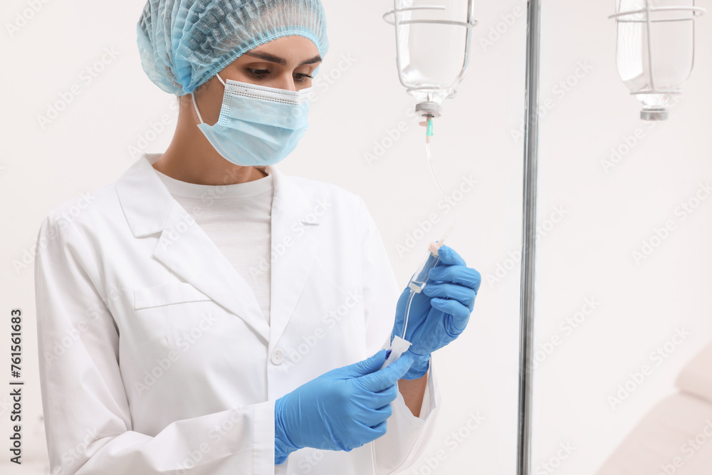 Nurse setting up IV drip in hospital Nurse setting up IV drip in hospital