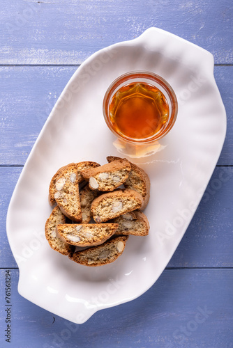 White tray with almond cantuccini and glass of sweet wine
