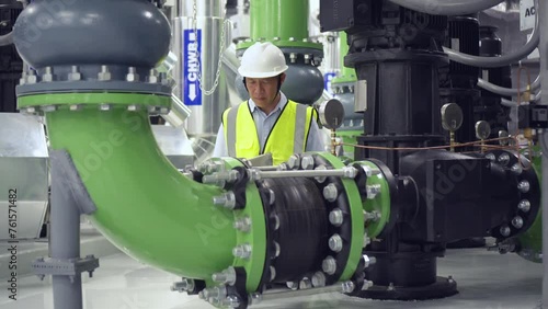 engineer work on chiller plant. worker checking pipe on chiller water plant.	
