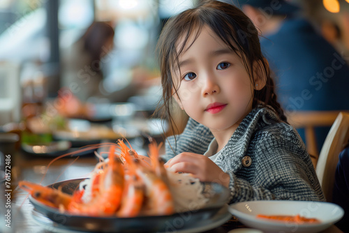 Young Girl Enjoying a Seafood Meal in a Restaurant