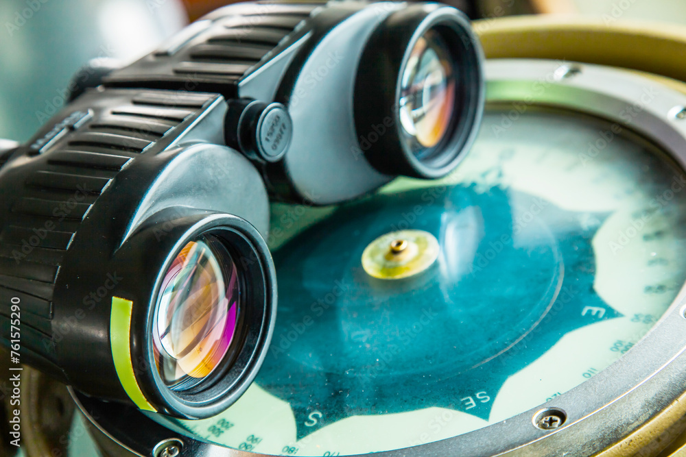 Fototapeta premium Optical binoculars lies on a gyrocompass, close-up.