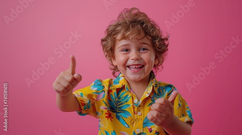 Photo of a cute boy pointing straight with his finger Wear a printed shirt. Isolated on a pink background.