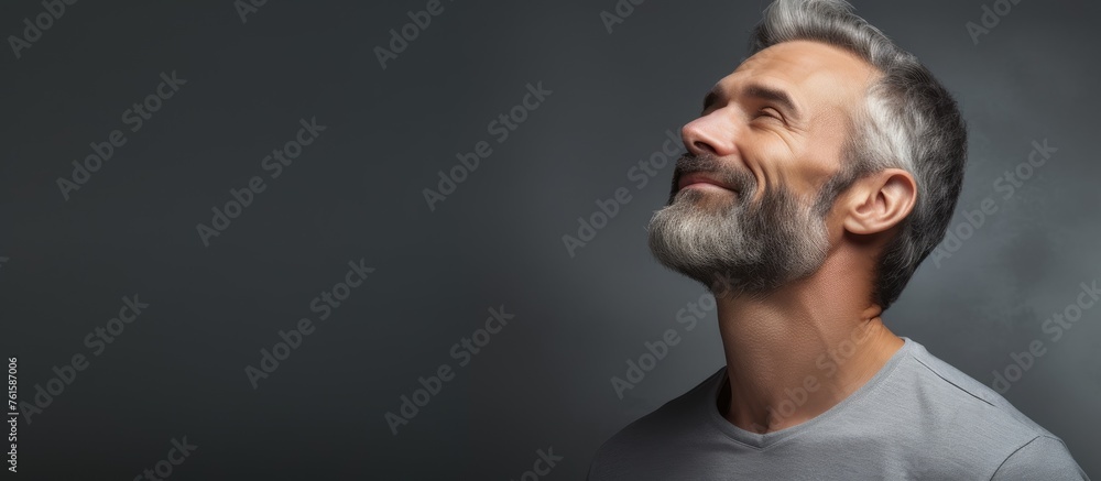 A man with a beard and moustache gazes at the sky, his facial hair fluttering in the breeze. His eyelashes cast shadows over his dark hat, adding to his mysterious appearance A man with a beard and moustache gazes at the sky, his facial hair fluttering in the breeze. His eyelashes cast shadows over his dark hat, adding to his mysterious appearance