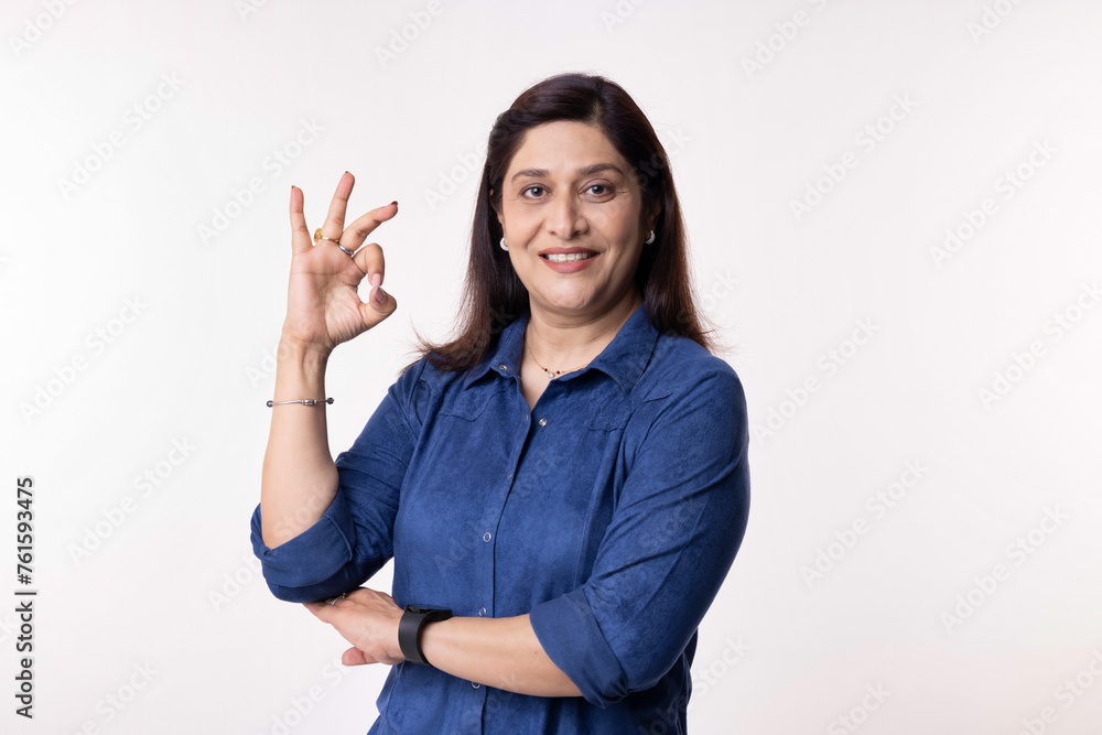 Portrait of confident businesswoman gesturing perfect on white background
