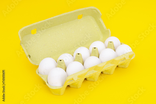 Cardboard egg rack with eggs on a yellow background
