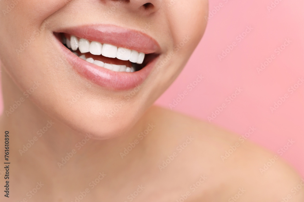 Woman with beautiful lips smiling on pink background, closeup Woman with beautiful lips smiling on pink background, closeup
