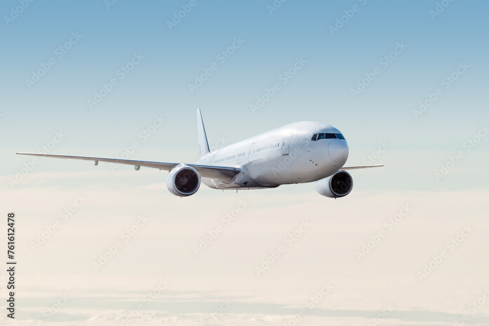 White wide body passenger airliner fly in the air above the clouds White wide body passenger airliner fly in the air above the clouds