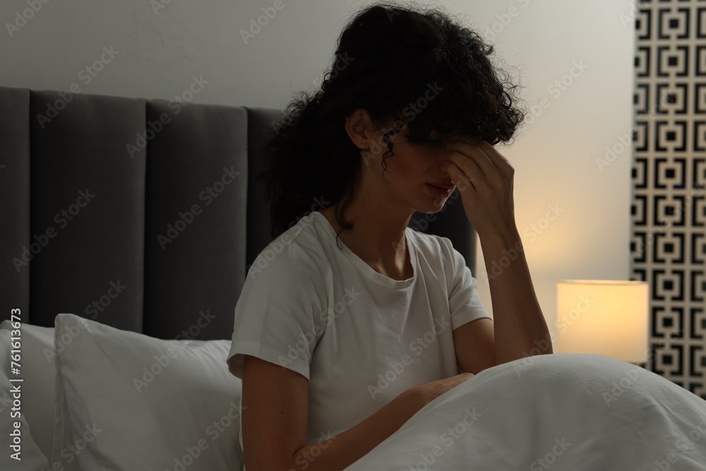 Young woman suffering from headache in bed at night Young woman suffering from headache in bed at night