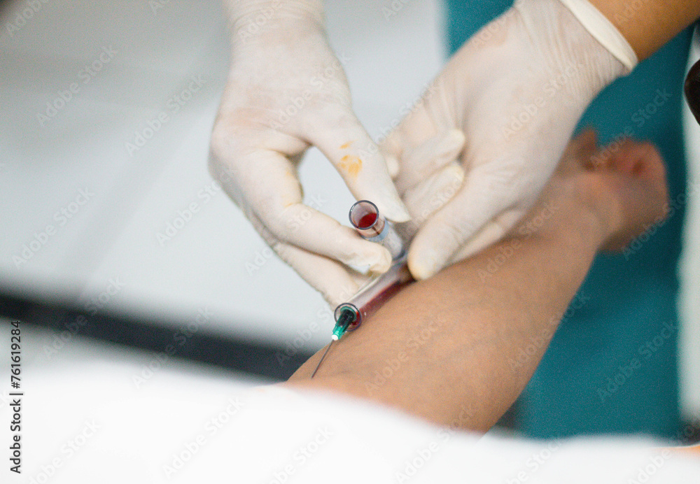 Doctora sacando muestras de sangre del brazo para un análisis de sangre,evaluación paciente - obrazy, fototapety, plakaty 