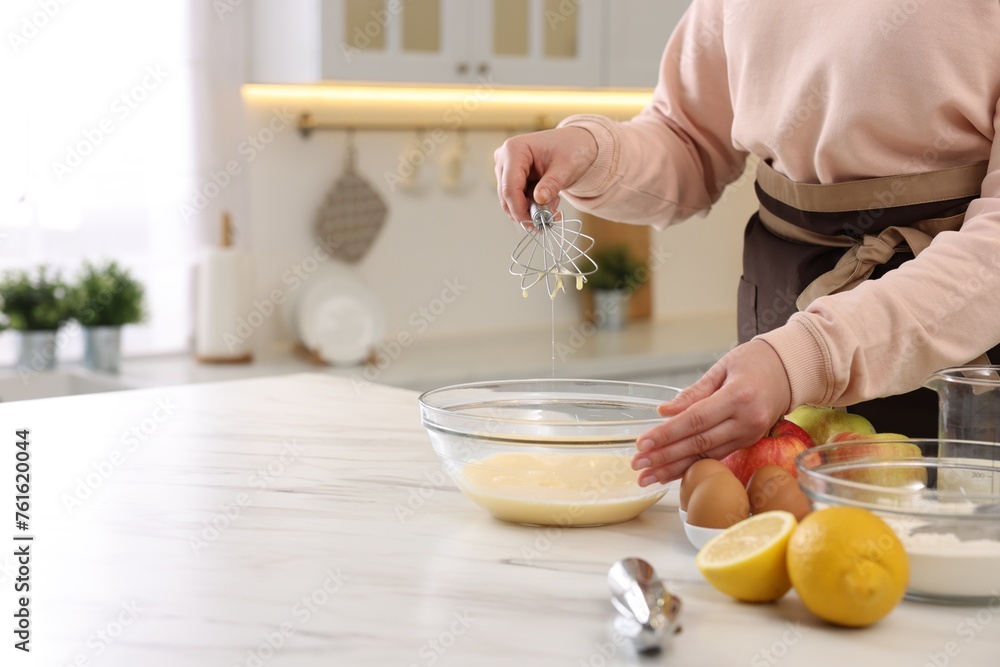 Woman whisking eggs in bowl at light marble table indoors, closeup. Space for text Woman whisking eggs in bowl at light marble table indoors, closeup. Space for text