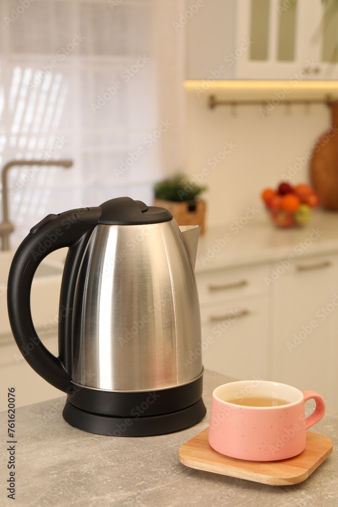 Electric kettle and cup on table in kitchen Electric kettle and cup on table in kitchen