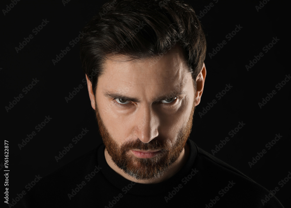Fototapeta premium Evil eye. Man with scary eyes on black background, closeup