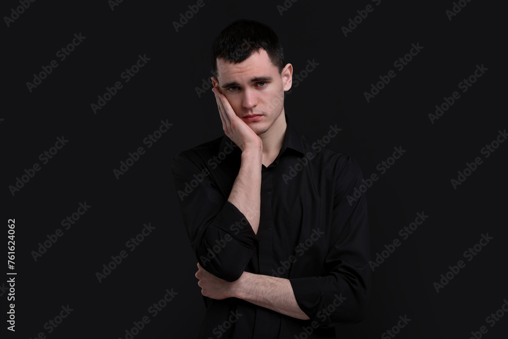 Obraz premium Portrait of sad man on black background