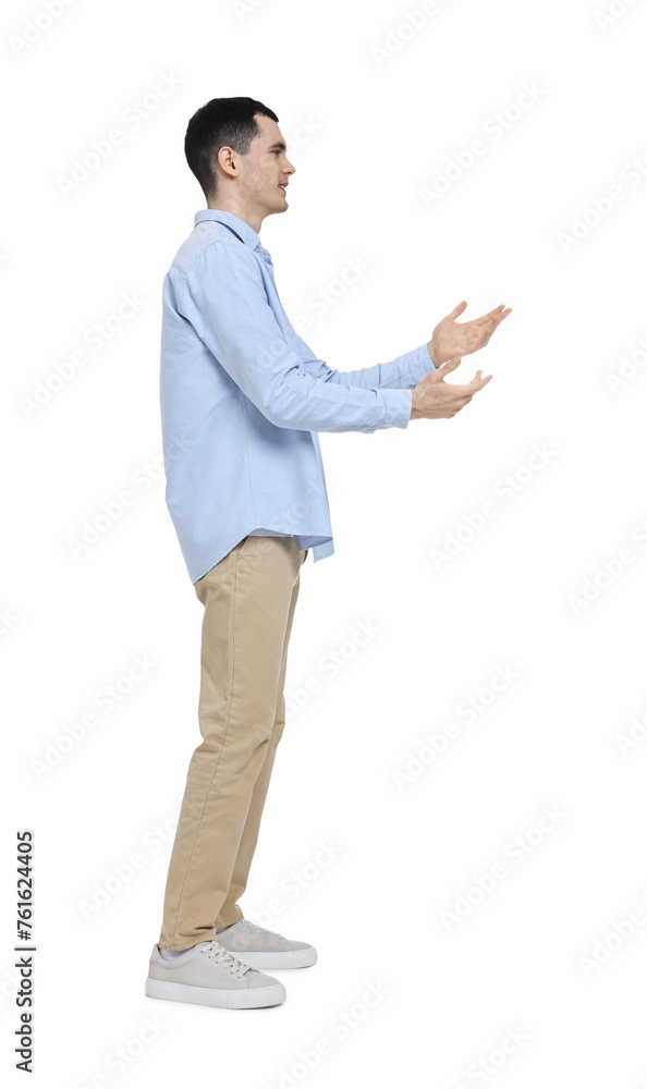 Young man in light blue shirt and beige pants on white background Young man in light blue shirt and beige pants on white background