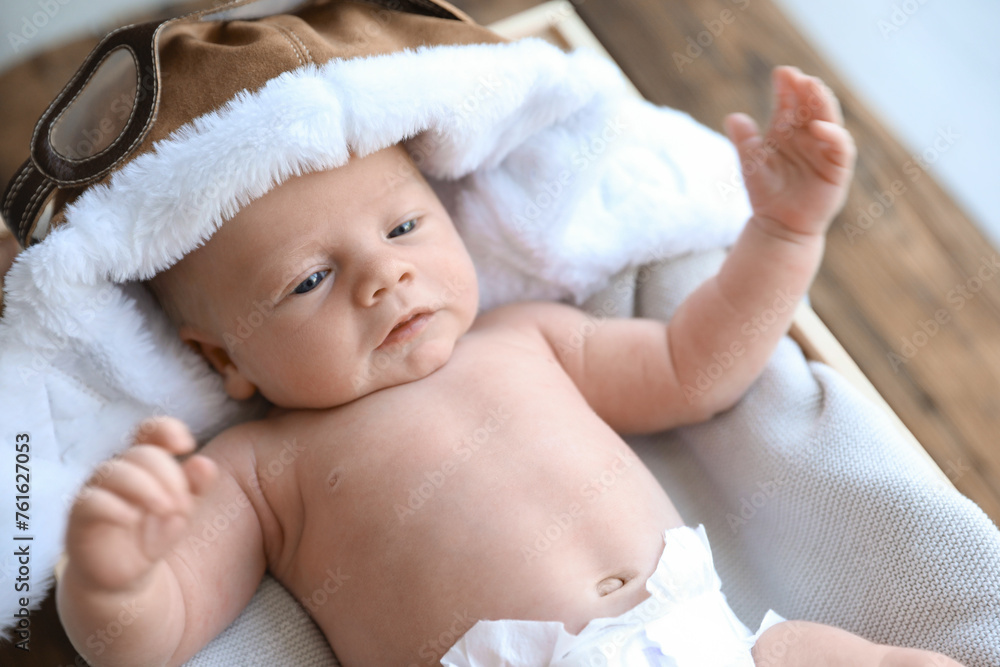 Cute newborn baby in aviator hat on blanket, closeup Cute newborn baby in aviator hat on blanket, closeup