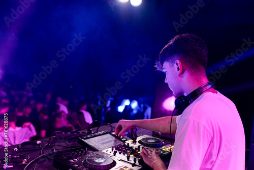 Rear side view of a dj working on a discotheque photo