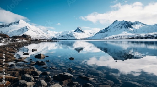 Winter lake landscape with frozen water and snowy mountains