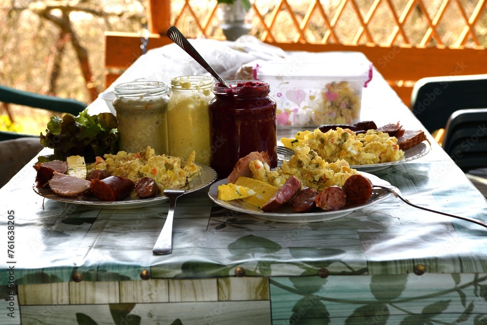 Easter table with salad, eggs, ham, sausage, beetroot and horseradish