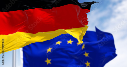 Flags of Germany and the European Union waving in the wind on a clear day photo