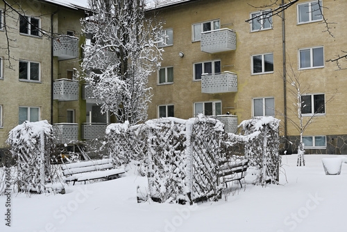 Snow-covered residential building with trees photo