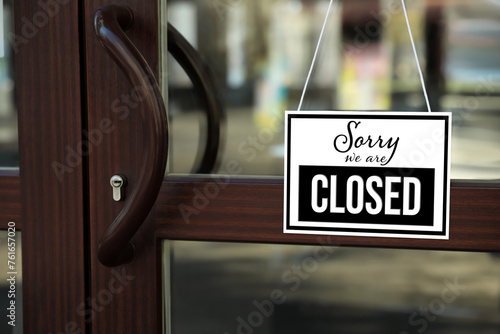Sorry we are closed sign hanging on glass door photo