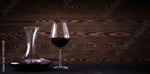 Decanter and glass with red wine on wooden rustic background