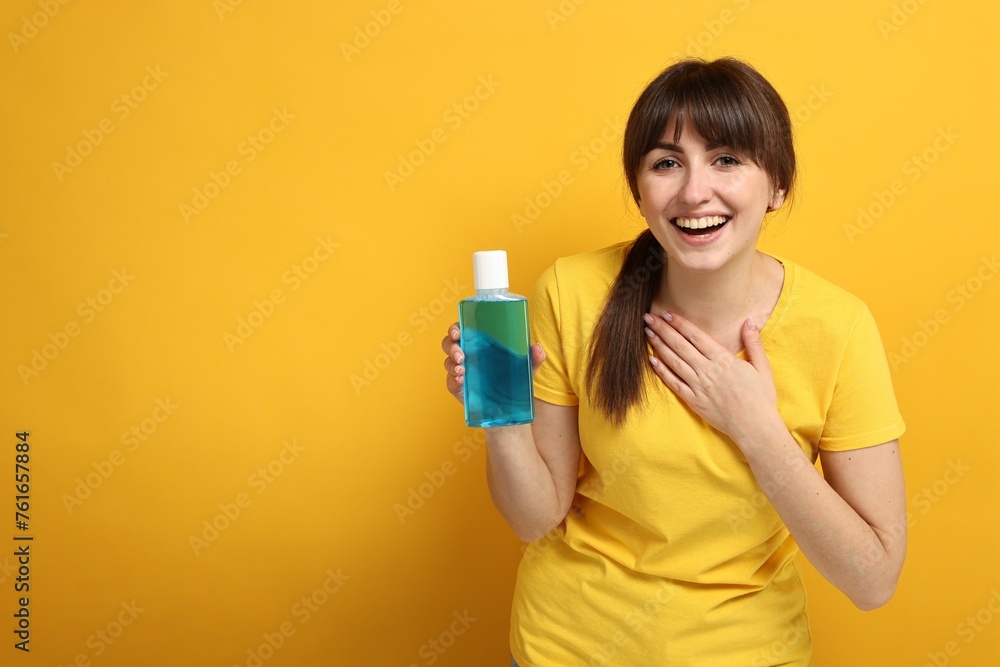 Young woman with mouthwash on yellow background, space for text Young woman with mouthwash on yellow background, space for text