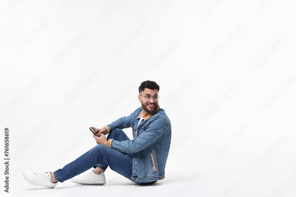 Handsome man using smartphone on white background, space for text Handsome man using smartphone on white background, space for text