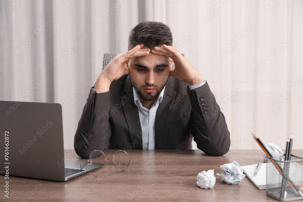 Tired sad businessman sitting at table in office Tired sad businessman sitting at table in office