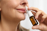 Medical drops. Woman using nasal spray indoors, closeup