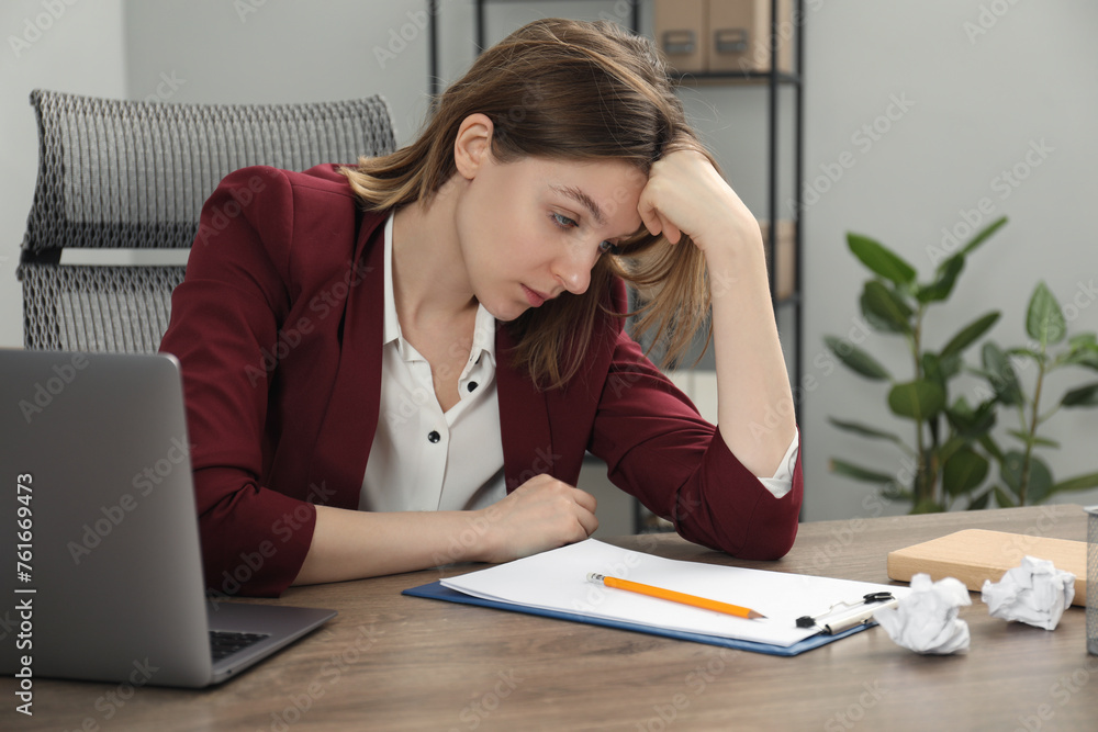 Sad businesswoman working at wooden table in office Sad businesswoman working at wooden table in office