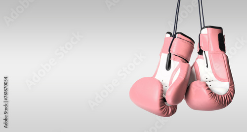 Breast cancer awareness. Pair of pink boxing gloves on light grey background, space for text. Banner design © New Africa