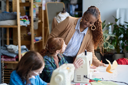 Portrait of Black adult woman talking to girl during atelier workshop class, copy space photo