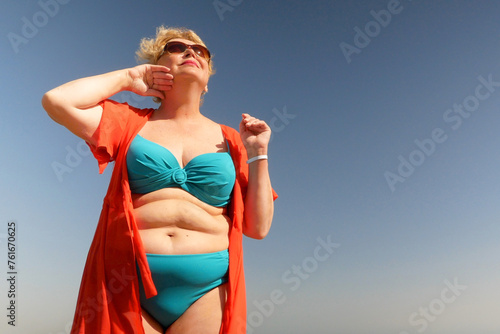 Slika na platnu Senior woman wiping the sweat from his forehead with a towel in sea beach, abnor