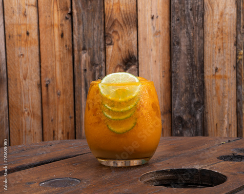 Cocktail. Closeup view of a tropical passion fruit daiquiri with lime and a rustic wooden background photo