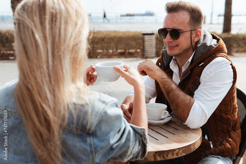 Joyful couple engaged in conversation over coffee at an outdoor cafe
