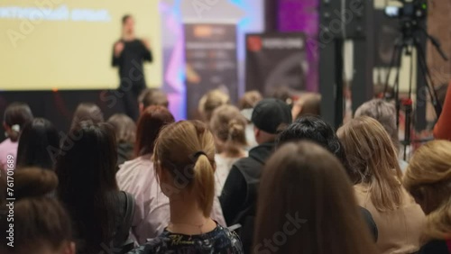 Dynamic female speaker gestures passionately during a tech innovation seminar. Panoramic view of an engaged audience at a technology conference. Suitable for themes tech presentations and innovative