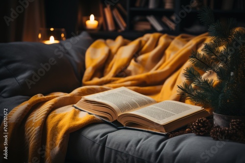 An open book resting on a couch next to a decorated Christmas tree