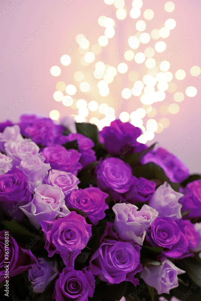 Bouquet of violet roses against blurred background, closeup. Funeral attributes