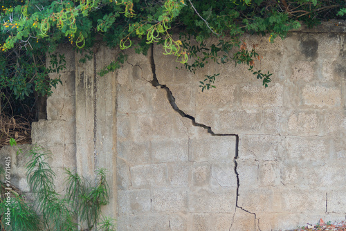 Quadro em tela Crack in a concrete fence made of cement blocks, appeared as a result of soil shrinkage in area of pole and as a result of rupture and partial destruction