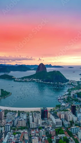 View of sunset on Rio De Janeiro looking towards Sugarloaf Mountain and the Atlantic ocean, Brazil. Aerial vertical drone hyperlapse. photo