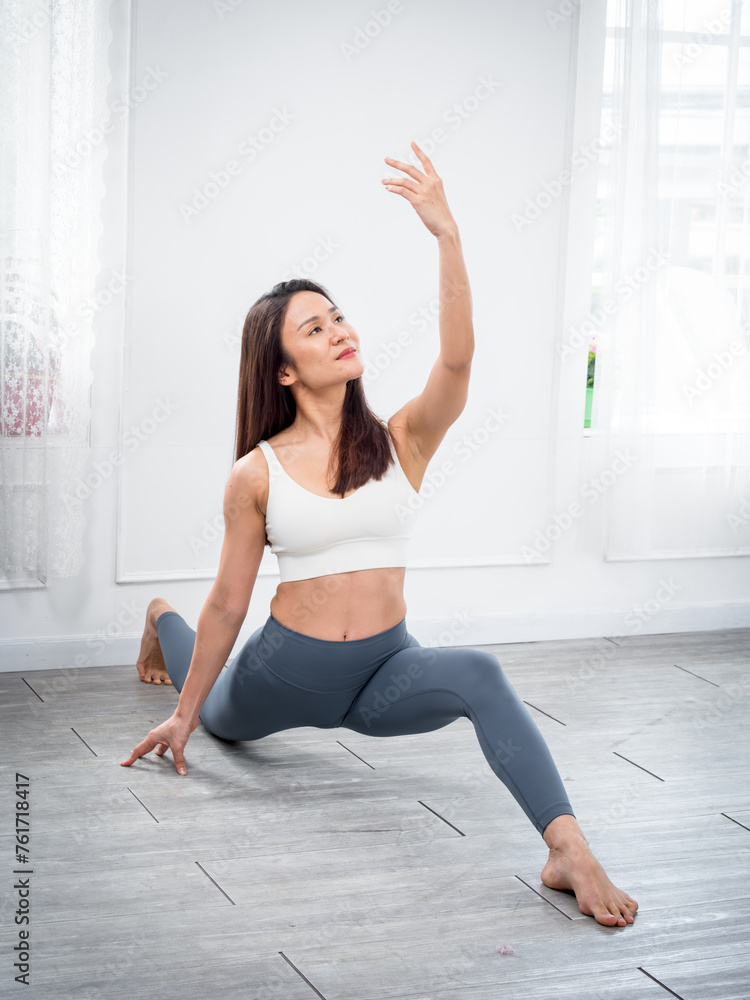 Attractive beautiful Asian women practice the pose during their yoga class in a gym. Two women practice yoga together. Attractive beautiful Asian women practice the pose during their yoga class in a gym. Two women practice yoga together.