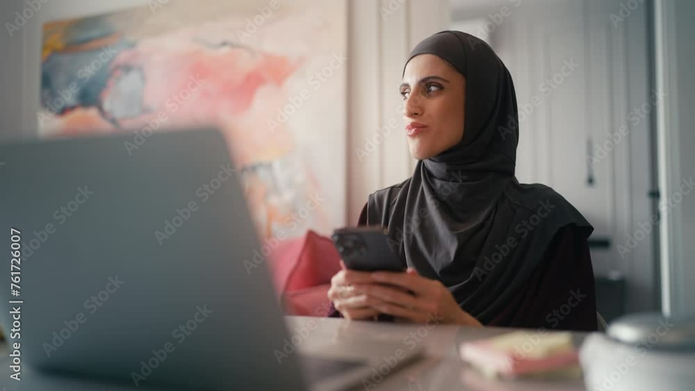 Young Arab woman using messenger app on smartphone, chatting online and smiling Young Arab woman using messenger app on smartphone, chatting online and smiling